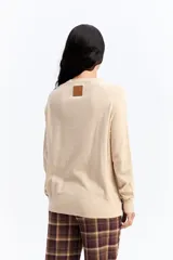 Sweater de punto negro con cuello redondo, manga larga y calce relajado. Presenta una costura vertical central en el frente y puños acanalados.