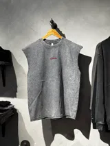 Musculosa gris unisex con efecto lavado desgastado, cuello redondo y la palabra 'Become.' bordada en rojo en el centro de la espalda.