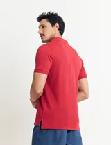 Remera tipo polo de color azul, con cuello clásico, cierre de botones y mangas cortas con terminación acanalada.