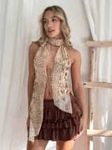 Top halter con estampado animal print en tonos beige y marrón, con cuello alto y abertura en el pecho que se ajusta con lazos.