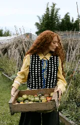 Chaleco tejido a mano en crochet con diseño de cuadros en blanco y negro, con terminaciones y lazos de ajuste en color azul eléctrico. Es una prenda reversible de corte recto.
