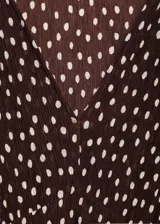 Vestido midi de corte recto con estampado de lunares, cuello en pico y mangas cortas. Presenta cierre de cremallera lateral y abertura en el bajo.