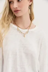 Remera azul de algodón peruano con textura jaspeada, de moldería holgada y buena caída, con mangas largas que se ajustan hacia la muñeca y se ensanchan debajo del brazo.