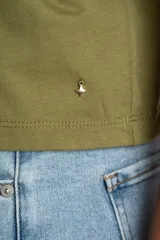 Remera negra de algodón con mangas cortas abullonadas que presentan detalles de encaje bordado y calado en los extremos.