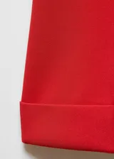 Pantalon de vestir color rojo, de corte flare con tiro medio. Presenta costuras verticales frontales, bolsillos laterales y ruedo con dobladillo ancho.