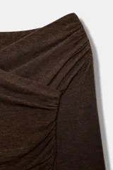 Top de manga larga con escote cruzado y detalle de tejido drapeado en el frente. Presenta un corte ajustado y bajo recto.