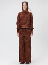 Sweater de tejido de punto jacquard con diseño geométrico, cuello redondo y puños acanalados en contraste de color verde y beige.