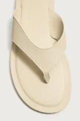 Sandalias de cuero color beige con acabado abatanado, diseño de dos tiras en el empeine tipo chancla y suela plana a tono.