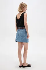 Minifalda de denim en color azul oscuro, con tiro alto, bolsillos delanteros y traseros, costuras en contraste y cierre frontal con botón y cremallera.