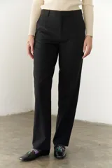 Pantalón negro de corte recto y cintura alta, con bolsillos laterales y cierre.