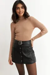 Media polera de punto acanalado con acabado metalizado, cuello alto y mangas largas ajustadas.