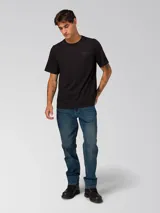 Remera de algodón de corte clásico y cuello redondo, color negro. Presenta un diseño minimalista con un pequeño gráfico bordado en el pecho y un parche de la marca en la manga izquierda.