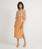 Camisa de gasa color beige con estampado de lunares marrones, cuello mao, mangas 3/4 abullonadas y cierre frontal con botones.