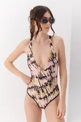 Malla enteriza con estampado animal print tipo cebra en tonos bordó y negro, con breteles cruzados en la espalda y bordes en color celeste.