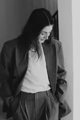 Blazer oversize de corte recto con cuello solapa, manga larga con hombreras y cierre frontal cruzado con botones. Presenta diseño de raya diplomática, bolsillos delanteros y forro interior.