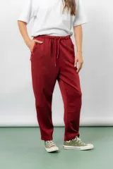 Pantalón jogger de calce relajado color bordó intenso, con cintura elastizada y lazo regulable. Cuenta con bolsillos laterales con cierre invisible y silueta recta levemente afinada.