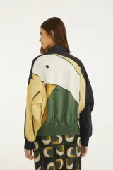 Campera corta Vento Tuca Tropical ligera de cuello alto y cierre frontal, con diseño colorido inspirado en la naturaleza.