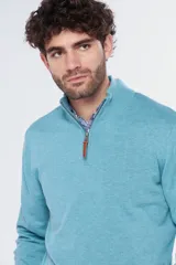 Buzo liso de punto fino en hilo de algodón color azul marino, con cuello alto y cierre frontal parcial con detalle de tirador de cuero.