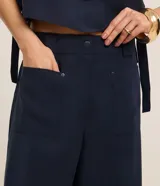 Pantalón pantacourt azul marino de viscosa, con cintura elástica, bolsillos delanteros y detalle de lazo en la cintura.