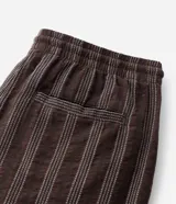 Bermuda masculina de corte recto confeccionada en tejido jacquard con textura y estampado de rayas verticales en tonos marrones. Cuenta con cintura elástica con cordón ajustable y bolsillos laterales.