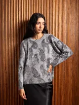 Buzo de punto gris con estampado de tigres en color negro, cuello redondo y mangas largas con puños acanalados.