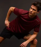 Remera deportiva masculina de manga corta con cuello redondo, confeccionada en tejido técnico con tecnología Dry para mayor transpirabilidad. Presenta detalles reflectantes en los hombros y un diseño liso en color verde melange.