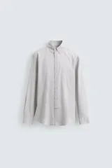 Camisa de corte regular fit confeccionada en tejido de algodón con estampado de cuadros pequeños. Presenta cuello abotonado, manga larga con puños abotonados, bolsillo plastrón en el pecho y cierre frontal con botones.
