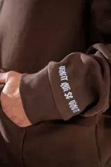 Campera con capucha y cierre frontal, de corte boxy y diseño holgado en color marrón chocolate. Presenta logo estampado en el pecho y detalles en las mangas.