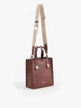 Cartera tipo tote pequeña de cuero color tostado, con doble asa superior y herrajes metálicos plateados en forma de llama en la base de las manijas. Presenta el logo de la marca estampado en la parte inferior frontal.