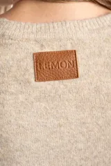 Sweater de punto con textura acanalada vertical, color beige melange, de cuello redondo y manga larga con puños rectos.