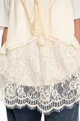 Camiseta de corte oversize con escote redondo y mangas cortas, que incorpora un top de satén y encaje superpuesto con diseño de tirantes finos y detalle de lazo frontal.