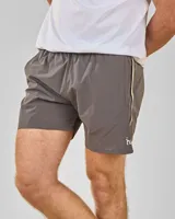 Short de baño gris con cintura elástica, bolsillos laterales y logo blanco en la pierna. Presenta una franja vertical blanca y dorada en los laterales.