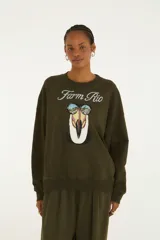 Buzo verde militar de cuello redondo y manga larga, con estampa frontal de un tucán con lentes de sol y el texto "Farm Rio".