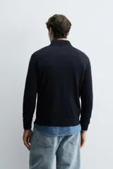 Jersey de punto de lana con ajuste regular, cuello subido y cierre frontal con botonadura. Presenta manga larga y acabados en rib en puños y ruedo.
