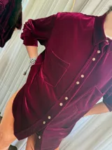 Camisa de terciopelo color beige, de corte recto, con cuello clásico, cierre frontal con botones y dos bolsillos de parche en el pecho.