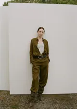 Camisa de lino color verde militar, de corte recto con cuello camisero, manga larga con puños abotonados, bolsillo de parche en el pecho y cierre frontal de botones.