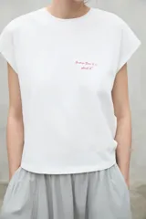 Camiseta blanca de manga corta con texto rojo "Because there is no planet B" en el frente.