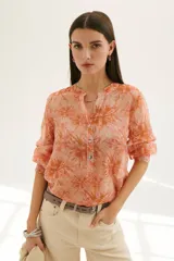 Camisa color coral con estampado floral, cuello mao y mangas 3/4 con volados.