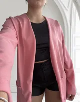 Blazer rosado de crepé con corte recto, solapas y bolsillos frontales.