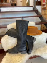 Botas altas de montar de cuero color marrón, con diseño plano y suela de goma.