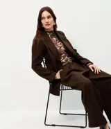 Blazer oversized estructurado marrón de corte cruzado con solapa amplia, bolsillos integrados y cuatro botones frontales.