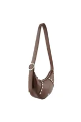 Cartera tipo bandolera de Las Oreiro en color marrón con acabado brillante. Presenta un diseño de media luna con detalles de tachas metálicas circulares en los laterales y un aplique metálico con forma de labios en la parte inferior central.