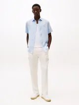 Camisa celeste de lino con corte regular, manga corta, cuello abotonado y logo de Tommy Hilfiger bordado en el pecho.