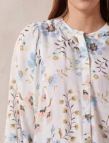 Blusa de gasa estampada con flores, marca Zac & Rachel. Tiene cuello a la base, abertura central con botones y mangas 3/4 abullonadas.