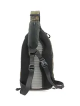 Mochila tipo morral de un solo hombro Merrell, con estampado camuflado en tonos verdes y marrones. Cuenta con cierre frontal vertical, panel trasero de espuma EVA y correas ajustables para uso ambidiestro.