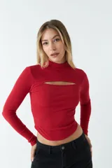 Top rojo de punto canalé, de manga larga y cuello alto con abertura en el pecho.