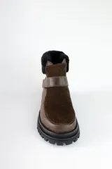 Bota corta de cuero marrón con puntera de gamuza, cuello de piel sintética negra, cierre con velcro y suela track negra.