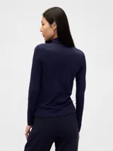 Remera de manga larga con cuello alto tipo polera, confeccionada en tejido suave y ajustado al cuerpo.