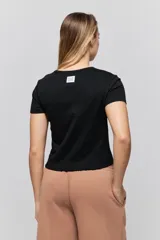 Remera negra de manga corta, con corte ajustado y estampa frontal en tono rosado que dice "Todo bien ya lloré" junto con un personaje ilustrado.