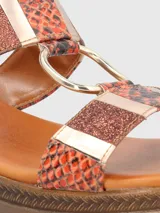 Sandalia Hush Puppies en colaboración con Massimo Cerutti, con plataforma baja y tiras con estampado de piel de serpiente en tonos naranja, combinadas con detalles metálicos, apliques con glitter y una argolla dorada central. Cuenta con tira ajustable con hebilla en el talón.
